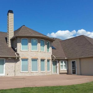 A sturdy two-story home updated by GRT Roofing with new gutters and neat roofing work.