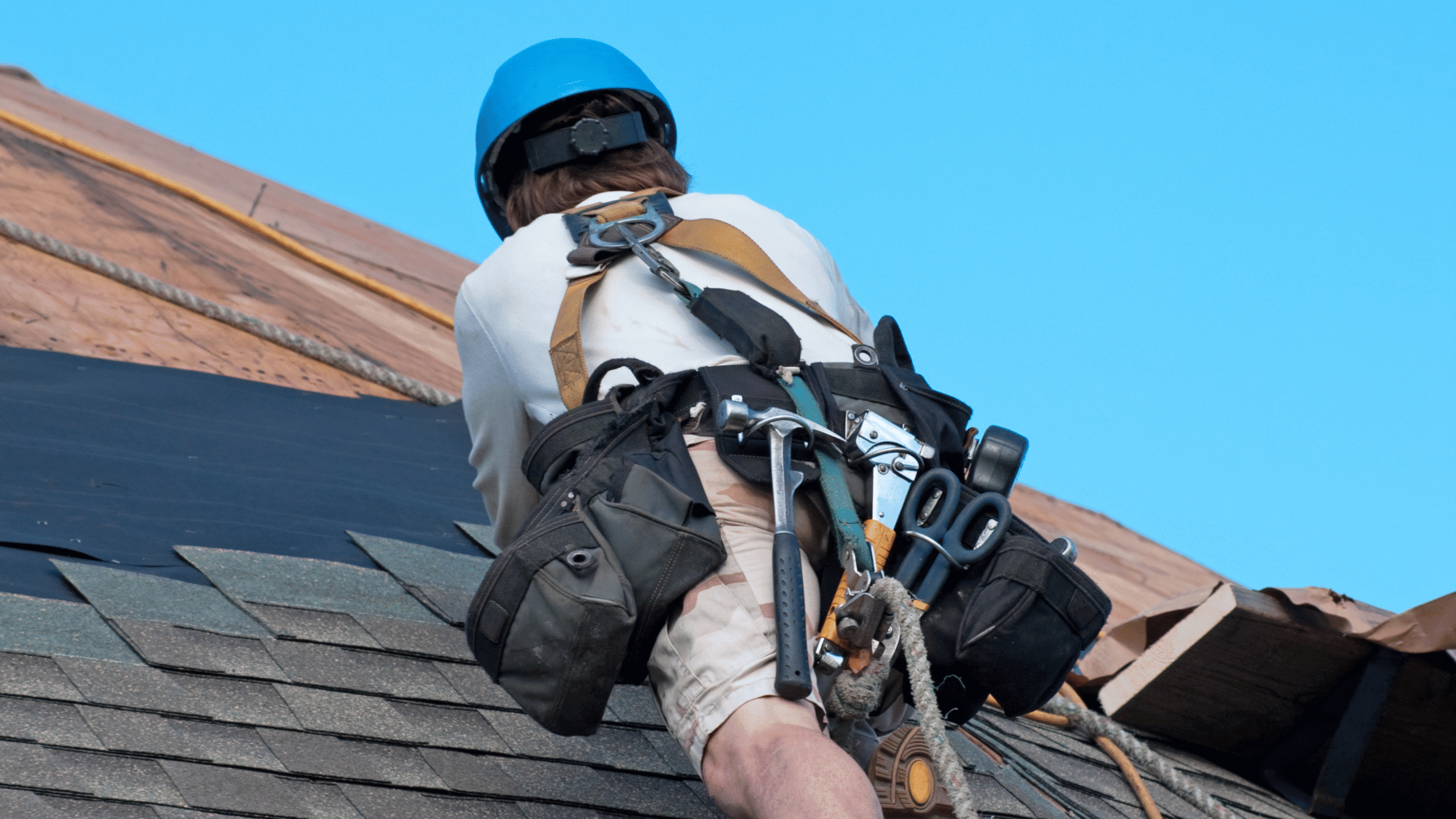 GRT Roofing worker repairs a sloped roof with safety and professionalism